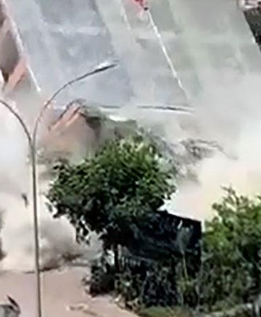 Apartmanın yıkımı sırasında, kaldırımdaki kadın enkaz altında kalmaktan son anda kurtuldu