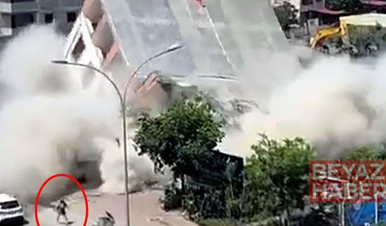 Apartmanın yıkımı sırasında, kaldırımdaki kadın enkaz altında kalmaktan son anda kurtuldu