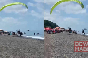 Sahilde motorlu yamaç paraşütüyle havalanırken tatilcilerin arasına daldı