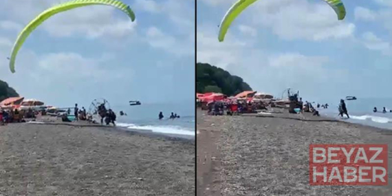 Sahilde motorlu yamaç paraşütüyle havalanırken tatilcilerin arasına daldı