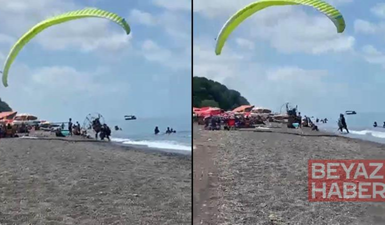 Sahilde motorlu yamaç paraşütüyle havalanırken tatilcilerin arasına daldı