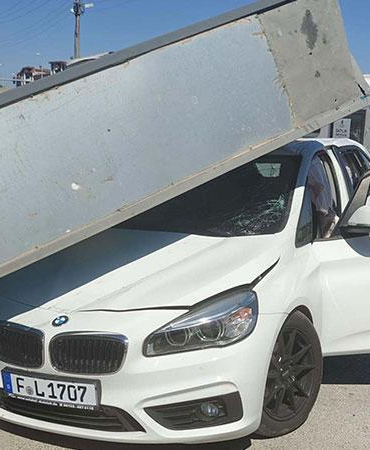 Üzerine reklam totemi devrilen otomobilin sürücüsü yara almadan kurtuldu