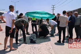 Yerdeki yaralı sürücüyü, ambulans gelene kadar plaj şemsiyesiyle güneşten korudular