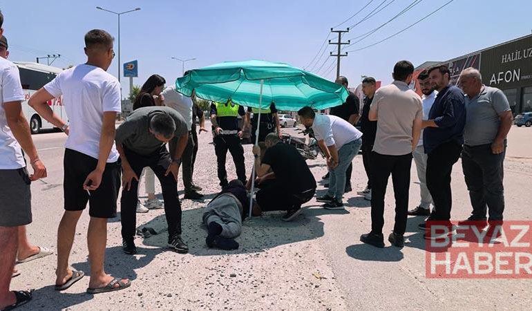 Yerdeki yaralı sürücüyü, ambulans gelene kadar plaj şemsiyesiyle güneşten korudular