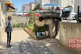 El freni çekilmeyen otomobil, hareket edip istinat duvarında asılı kaldı